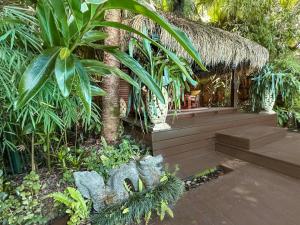 a tropical garden with a hut with a palm tree at Sanctuary in The Pocket in The Pocket