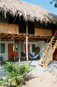 a straw hut with hammocks in front of it at Ipqua Hostel in Palomino