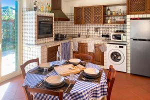 een keuken met een tafel met een blauw en wit tafelkleed bij PrimeStay in Nicolosi