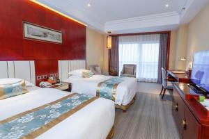 a hotel room with two beds and a flat screen tv at Yiwu Ocean Hotel - Original Best Western Premier Ocean Hotel in Yiwu