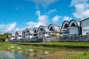 a row of houses next to a body of water at Asri Cinta Villa Ubud in Ubud