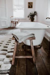 a white bath tub sitting on a wooden floor at The Postman's Cottage - Hinterland Luxury in Montville