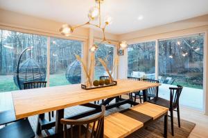 uma sala de jantar com uma mesa de madeira e cadeiras em Prattvilla -Catskill -Mountain Escape 5 BR ,3 bath with Hot tub em Prattsville