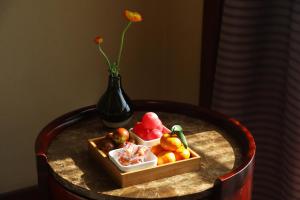 a table with a box of fruit and a vase at Yiwu Ocean Hotel - Original Best Western Premier Ocean Hotel in Yiwu