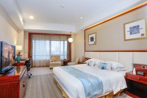 a hotel room with a large bed and a television at Yiwu Ocean Hotel - Original Best Western Premier Ocean Hotel in Yiwu