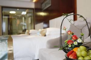 a bowl of fruit and flowers on a table in a hotel room at Yiwu Ocean Hotel - Original Best Western Premier Ocean Hotel in Yiwu