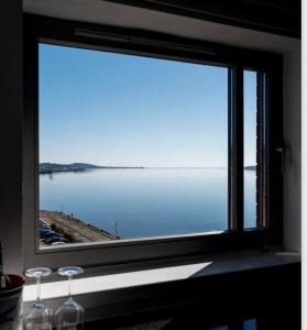 a window with a view of a body of water at River View Apartment - Central Dundee - Free Private Parking - Sky & TNT Sports - Lift Access - Superfast WIFI - Quiet Neighbourhood - 2 Bathrooms - Amazing Views - Balcony & Courtyard - Long Stays Welcome in Dundee