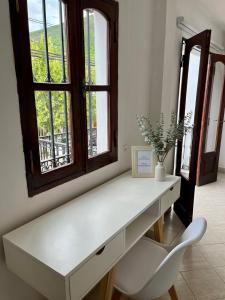 a white desk with a chair and a window at Blanc Hotel Boutique in Salta