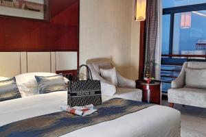 a hotel room with a bed and a chair at Yiwu Ocean Hotel - Original Best Western Premier Ocean Hotel in Yiwu