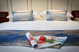 a hotel room with a bed with a magazine on it at Yiwu Ocean Hotel - Original Best Western Premier Ocean Hotel in Yiwu