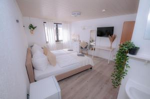 a white bedroom with a bed and a desk at Haus Kalos in Haiger