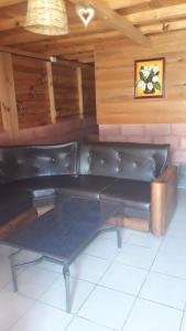a black leather couch in a room with wooden walls at Yatzil in La Trinitaria