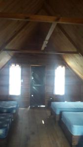 um quarto com camas azuis e janelas num sótão em Yatzil em La Trinitaria