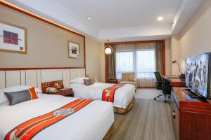 a hotel room with two beds and a television at Yiwu Ocean Hotel - Original Best Western Premier Ocean Hotel in Yiwu