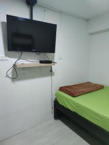 Habitación con TV en la pared y cama en HABITACION AMOBLADA SECTOR LAURELES-ESTADIO #1 Madrid, en Medellín