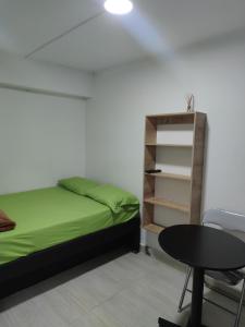a bedroom with a bed and a table and a shelf at HABITACION AMOBLADA SECTOR LAURELES-ESTADIO #1 Madrid in Medellín