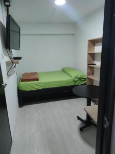 Habitación con cama, mesa y TV. en HABITACION AMOBLADA SECTOR LAURELES-ESTADIO #1 Madrid, en Medellín
