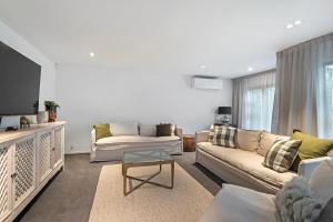 a living room with two couches and a tv at Winchester Haven in Christchurch