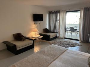 a living room with a couch and a chair and a television at Ti Koala in Les Terres Basses