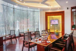 a dining room with tables and chairs and a television at Yiwu Ocean Hotel - Original Best Western Premier Ocean Hotel in Yiwu