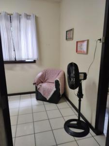 um quarto com uma cadeira e um secador de cabelo em Vô Doríbio em Torres