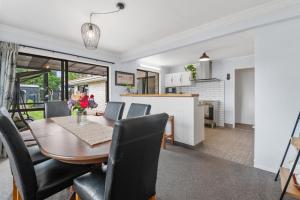 a dining room and kitchen with a table and chairs at Little Big House - Rotorua Holiday Home in Rotorua