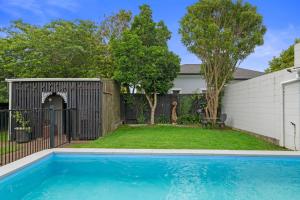 a backyard with a fence and a swimming pool at Little Big House - Rotorua Holiday Home in Rotorua