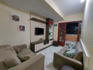 Sala de estar con 2 sofás y TV en Apartamento 12 - Bombinhas - 200 metros da praia, en Bombinhas