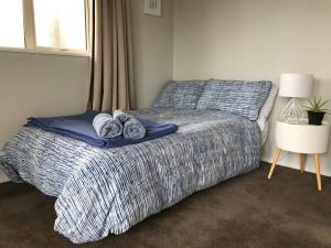 a bedroom with a bed with towels on it at Beachside Apartment in Hokitika