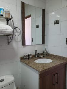 a bathroom with a sink and a mirror and a toilet at Cabañas #1 "A Pies del Valle" in Limache