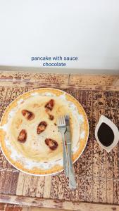 a plate of food on a table with a fork and knife at Nanda Homestay in Kuta Lombok
