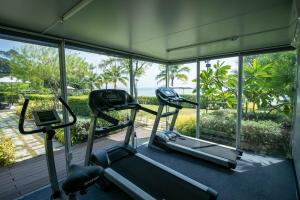 a gym with two treadmills and a view of the ocean at Escape Condominiums Beachfront Suites - Mae Phim in Rayong