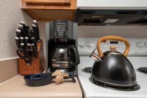 a black tea kettle sitting on top of a stove at Pet Friendly House in Resort Style Condo Near Disney, 4 Pools, Hot Tub & Gym in Kissimmee