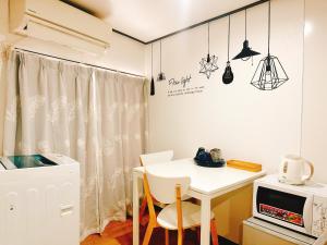 een kleine keuken met een witte tafel en een magnetron bij 通天閣南 in Osaka