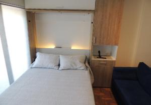 a small bedroom with a bed and a blue couch at MONOAMBIENTE VISTA AL RIO in Florida