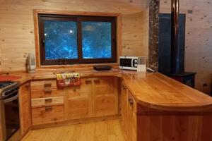 a kitchen with a wooden island with a microwave on it at Refugio Parque austral huilo huilo in Puerto Fuy