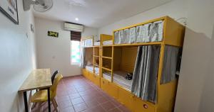 Cette chambre comprend 2 lits superposés et une table. dans l'établissement The Funky Village, à Siem Reap