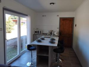 kuchnia z blatem z krzesłami i stołem w obiekcie Entre Ruta 5 Sur y Villarrica w mieście Villarrica