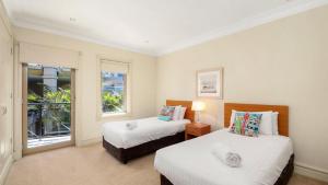 a bedroom with two beds and a window at Unit 25 - 3 Bed Ocean View in Terrigal +4 photos