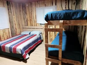 a bedroom with two bunk beds and a ladder at Cabaña Cunco parcela in Cunco