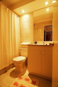 uma casa de banho com um WC, um lavatório e um espelho. em Vegas Apartamentos em Santiago