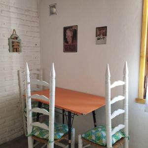 mesa de comedor con 2 sillas y mesa con en Los Piros Alojamiento en Esquel