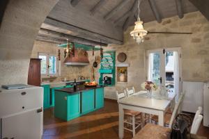 a kitchen with blue cabinets and a white table at Boutique Villa Petra Eleni in Fílippos