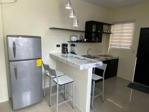 a kitchen with a stainless steel refrigerator and chairs at Hermosa suite privada y cerca de todo in Guayaquil