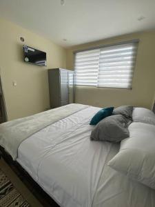 1 cama grande en un dormitorio con ventana en Hermosa suite privada y cerca de todo, en Guayaquil