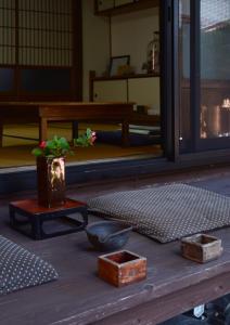 a wooden table with a potted plant on top of it at ZOKUIJINKAN GUESTHOUSe 続異人館 in Arita