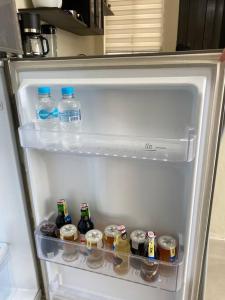an open refrigerator filled with bottles of water and drinks at Hermosa suite privada y cerca de todo in Guayaquil