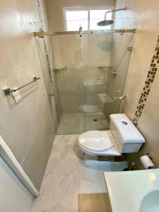 a bathroom with a white toilet and a shower at Hermosa suite privada y cerca de todo in Guayaquil