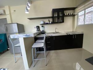 a kitchen with a sink and a counter with stools at Hermosa suite privada y cerca de todo in Guayaquil