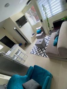 sala de estar con sofá y sillas azules en Hermosa suite privada y cerca de todo, en Guayaquil